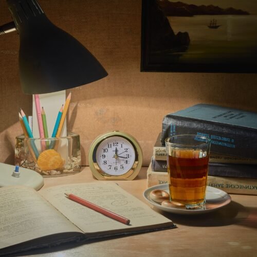 pexels-photo-37397517-37397517 A tranquil desk setup with books, tea, and a lamp, ideal for studying.